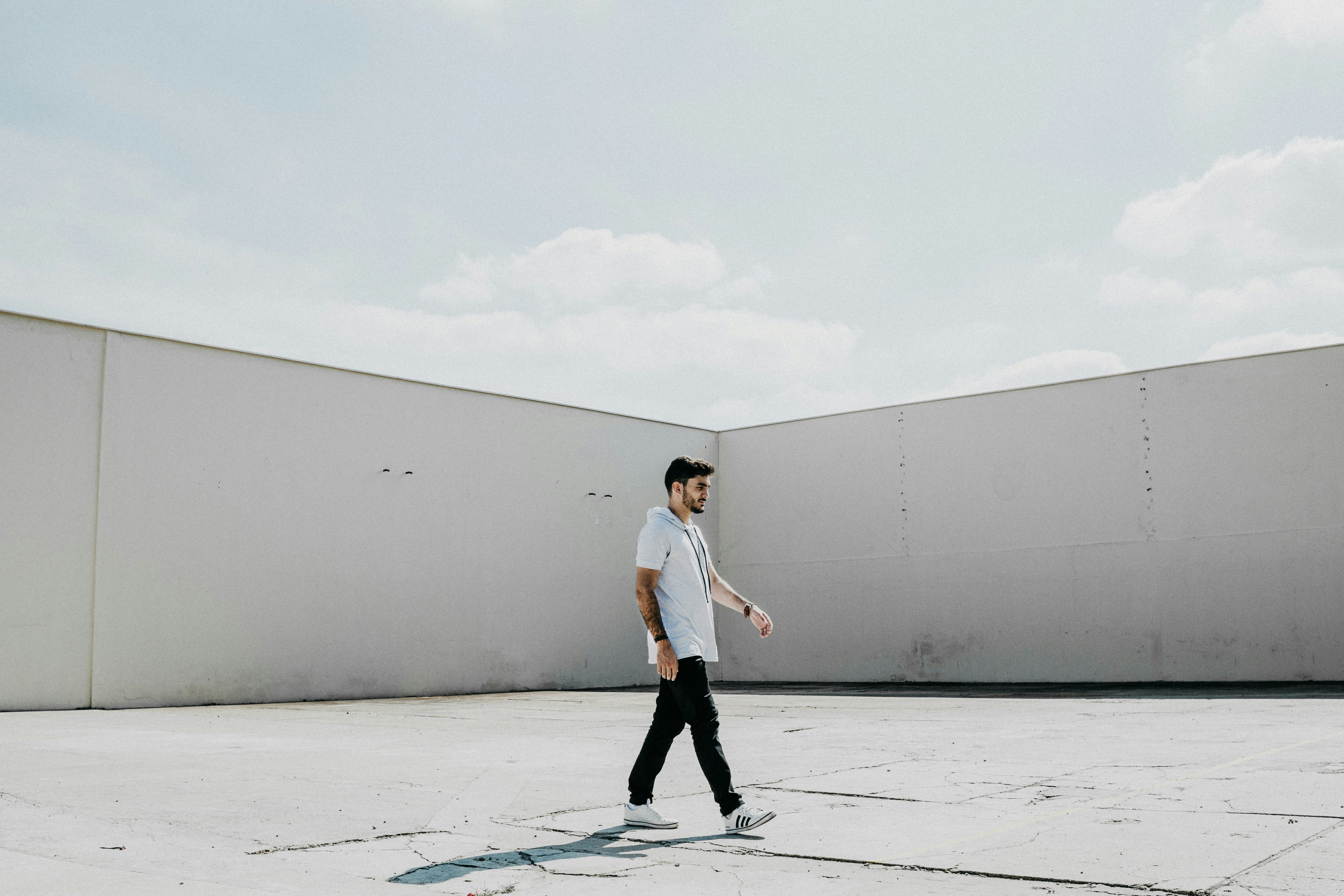 man walking on gray pavement